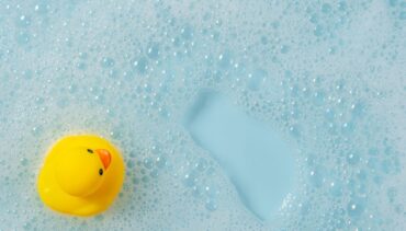 yellow rubber duck in bathtub with bubbles