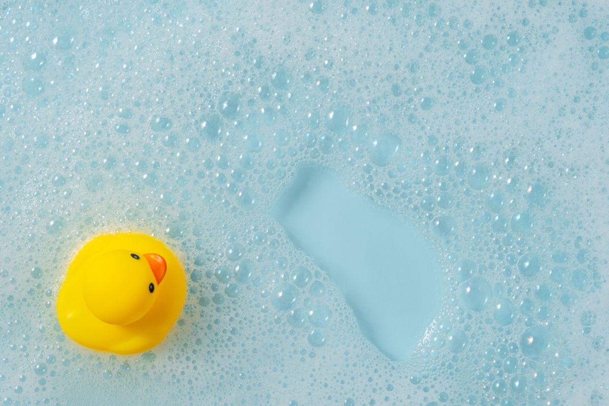 yellow rubber duck in bathtub with bubbles