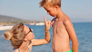 mom applies sunscreen on kid