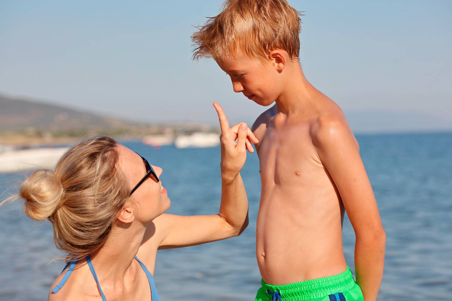 mom applies sunscreen on kid